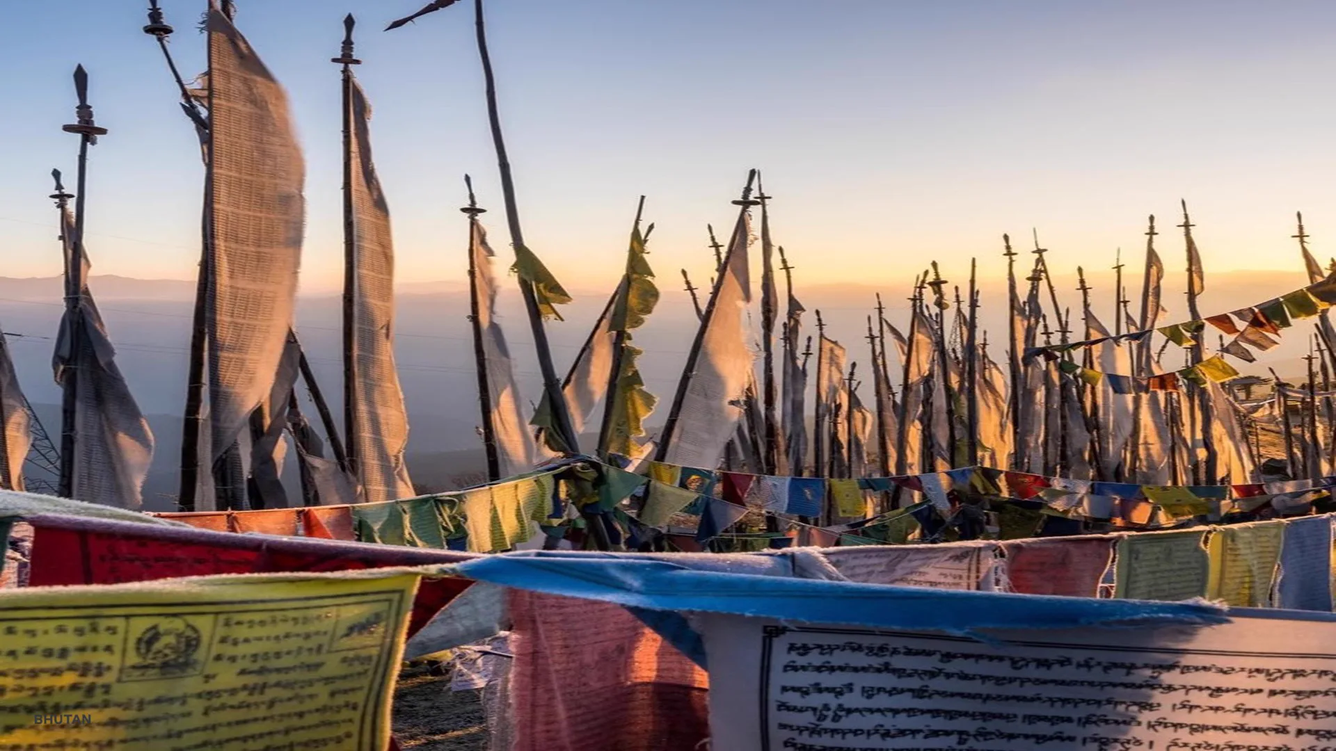 Prayer flags in a mountain valley in Bhutan — intimate, small-group travel